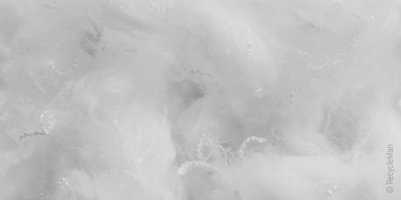 Close-up of a pillow filling made of fine, fluffy polyester fiberfill.