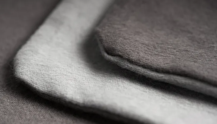 Photo: Two corners of the BODYGUARD flannel bed linen laid on top of each other so that the light and dark sides of the cover are visible.
