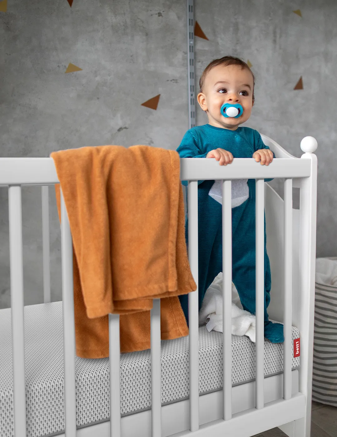 Baby stands in cot on the SuperBreeze® Kids Mattress.
