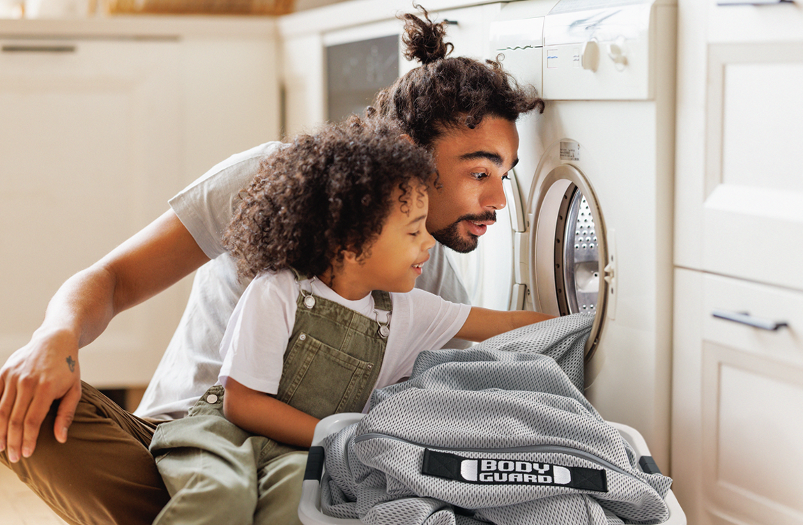 Photo: An adult and a child place the HyBreeze Cover in a washing machine