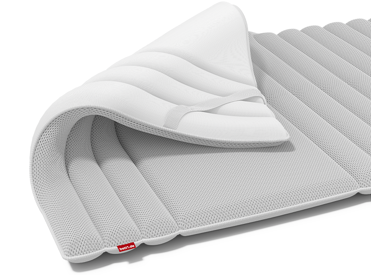 The BODYGUARD Topper with one corner folded down, so that both sides with different covers are visible.