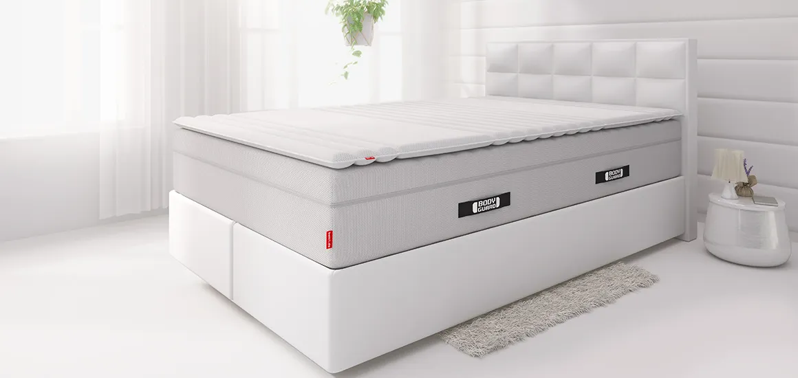 Auf einem Boxspringbett, liegt die BODYGUARD® Boxspring Matratze und darauf der BODYGUARD® Topper 120x200 cm.