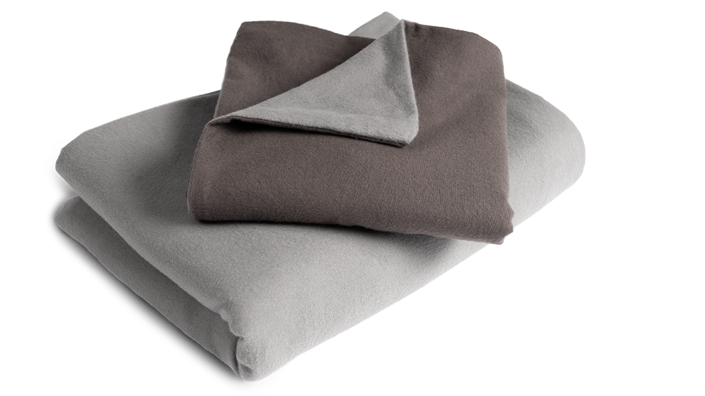 The folded flannel bed linen: the duvet cover is folded with the silver side facing outwards, the pillowcase with the anthracite-coloured side