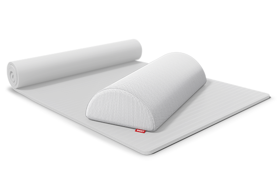 The knee and neck roll lies on a thin mat that is half rolled up.	