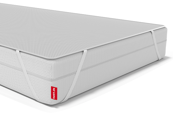 The BODYGUARD® Kids Mattress Protector for children's mattresses lies folded up on the bett1 baby mattress, with the Oeko-Tex® Standard 100 seal next to it.