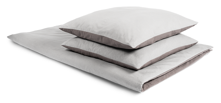 Two pillows lie neatly on top of each other on a folded duvet. The bedding is covered with winter bedding measuring 200x220 cm.