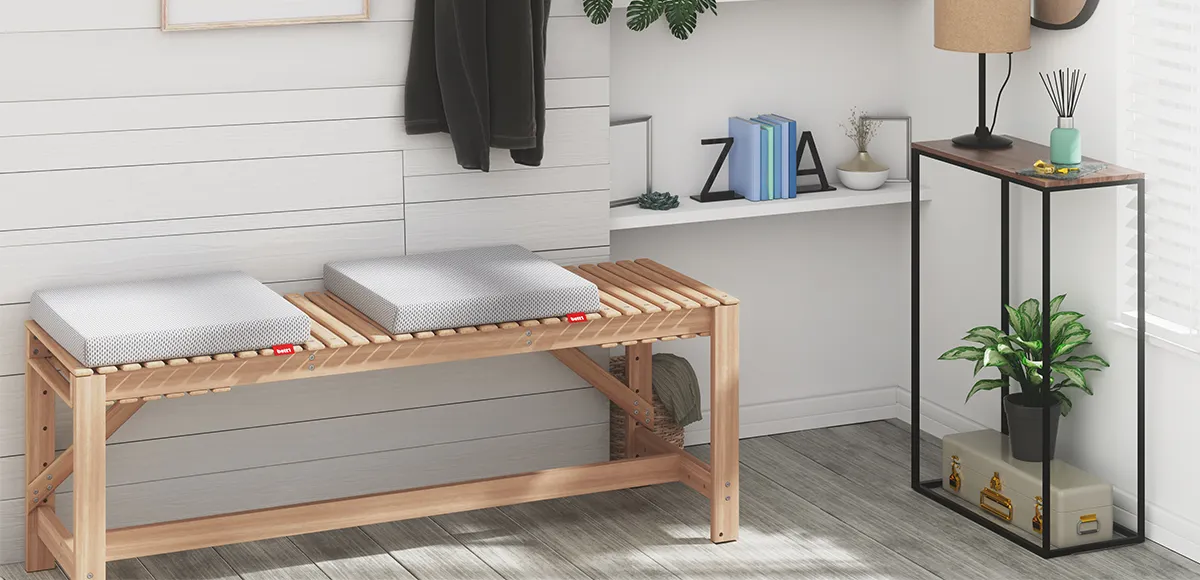 A bench under a coat rack, with two BODYGUARD seat cushions on it