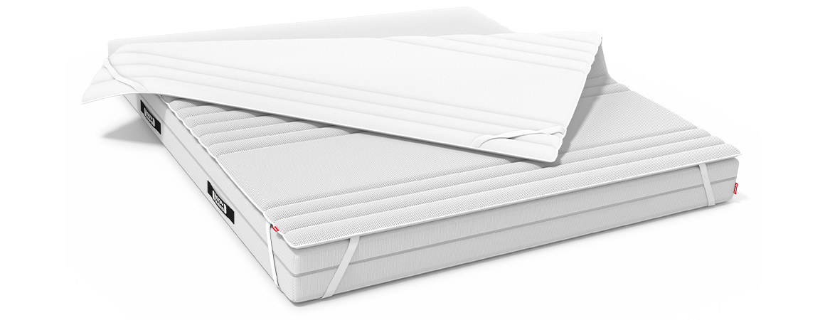 The BODYGUARD Topper is stretched over a BODYGUARD Mattress. One corner has been folded up so that the differently covered sides of the topper are visible.