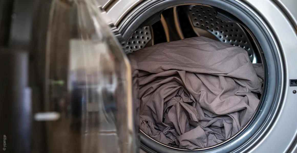 Photo: The BODYGUARD fitted sheet lies inside an open washing machine.