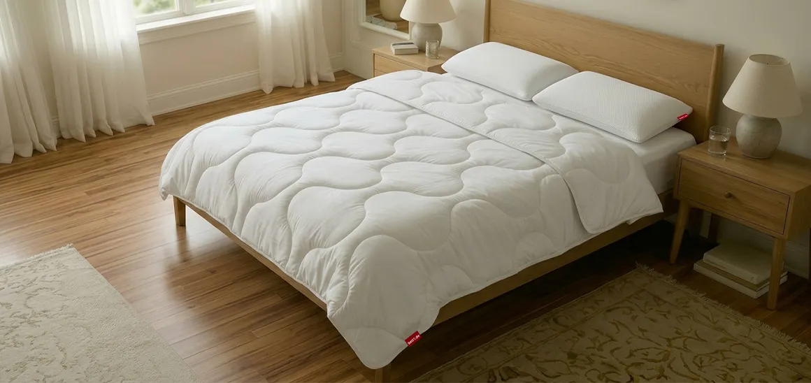 Photo: A double bed stands in a bedroom. On it lie two BODYGUARD pillows and a BODYGUARD double duvet.