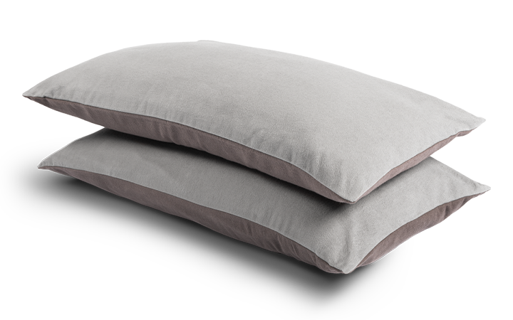 Two narrow cushions 80x40cm, covered with flannel bed linen, lie on top of each other. The upper side is light, the lower side dark.