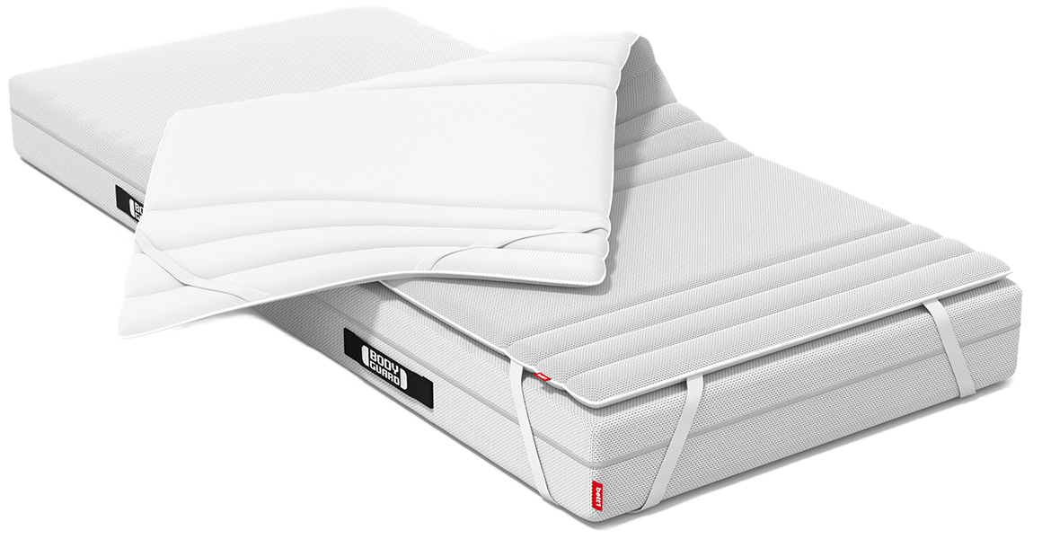 Eine BODYGUARD® Matratze halb bezogen mit dem BODYGUARD® Topper. Eine Topper-Hälfte ist umgeklappt und gibt die Sicht auf die zweite Bezugsseite frei. 