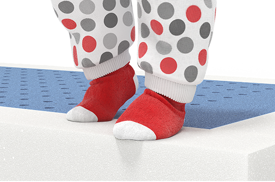 Two children's feet stand on the reinforced edge of the SuperBreeze Kids Mattress