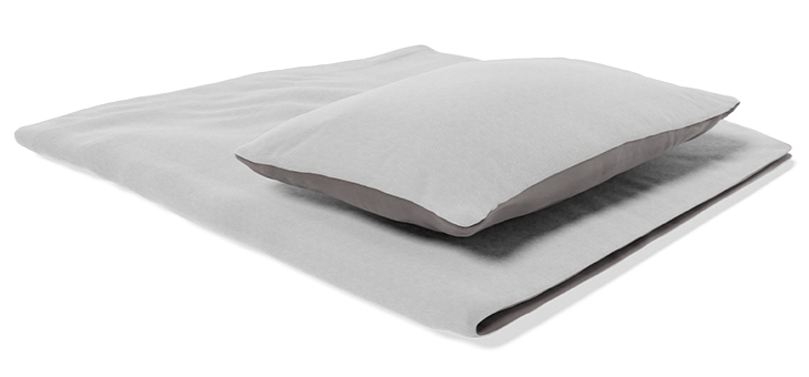 A pillow rests on a duvet folded in half. The duvet and pillow are covered with BODYGUARD flannel bed linen.