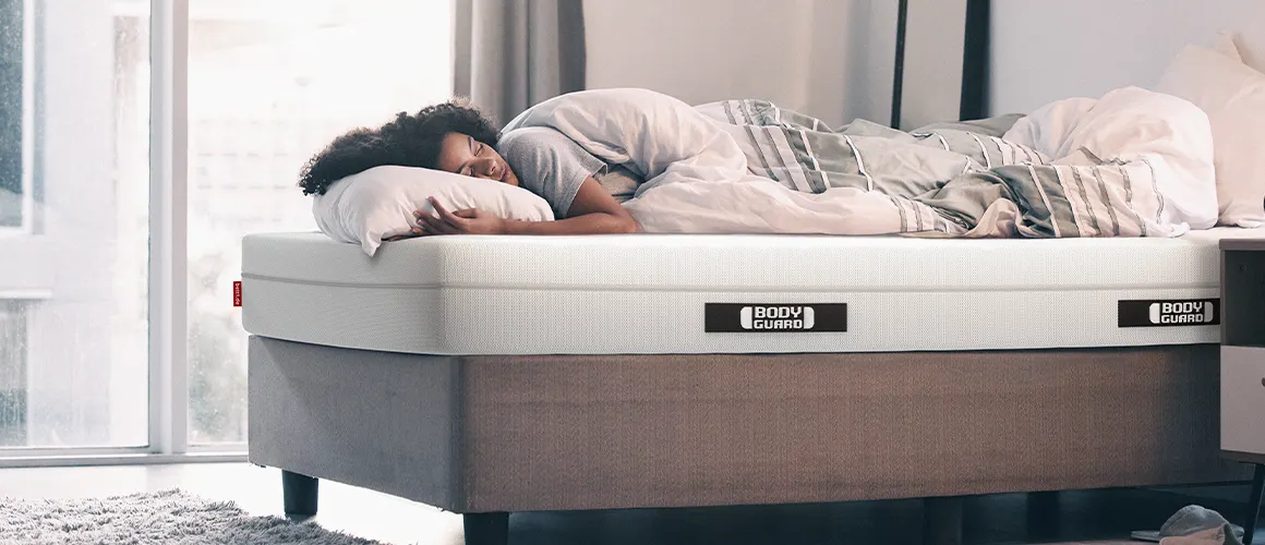 A person sleeping peacefully on a BODYGUARD mattress.
