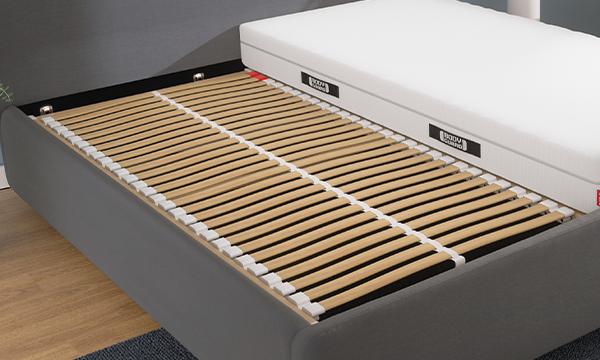 The BODYGUARD Slatted Frame Basic 90x190 inside a bed frame. The BODYGUARD Mattress is placed beside it.