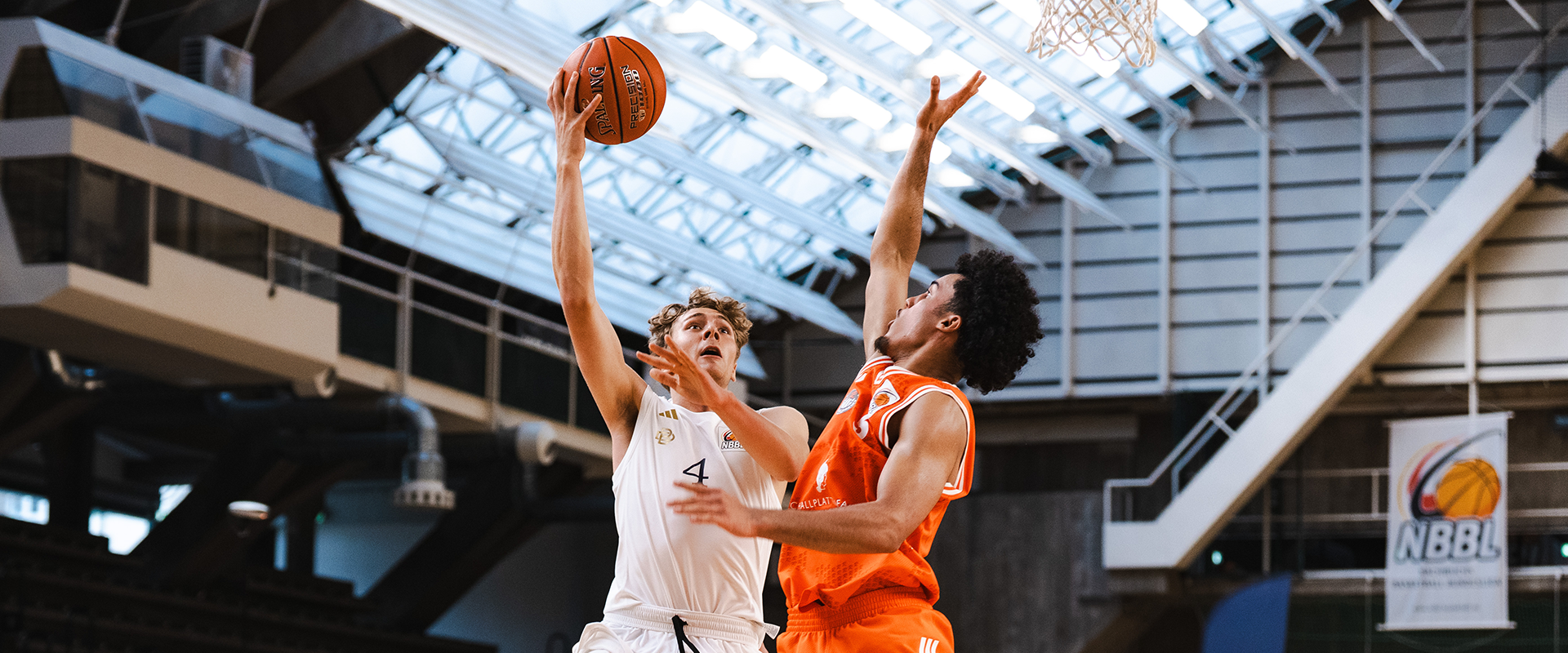 Photo: A player of the Berlin Braves jumping, below him two players in blue jerseys.