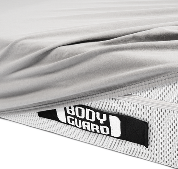 A BODYGUARD mattress half-covered with the BODYGUARD jersey fitted sheet.