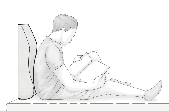 Illustration: Eine Person sitzt an das Venenkissen gelehnt im Bett und liest ein Buch.	