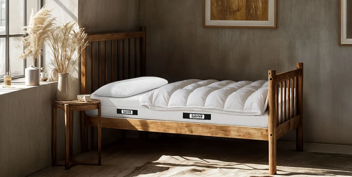 Photo: A BODYGUARD mattress 90x190 cm in an antique wooden bed in a historically furnished bedroom.