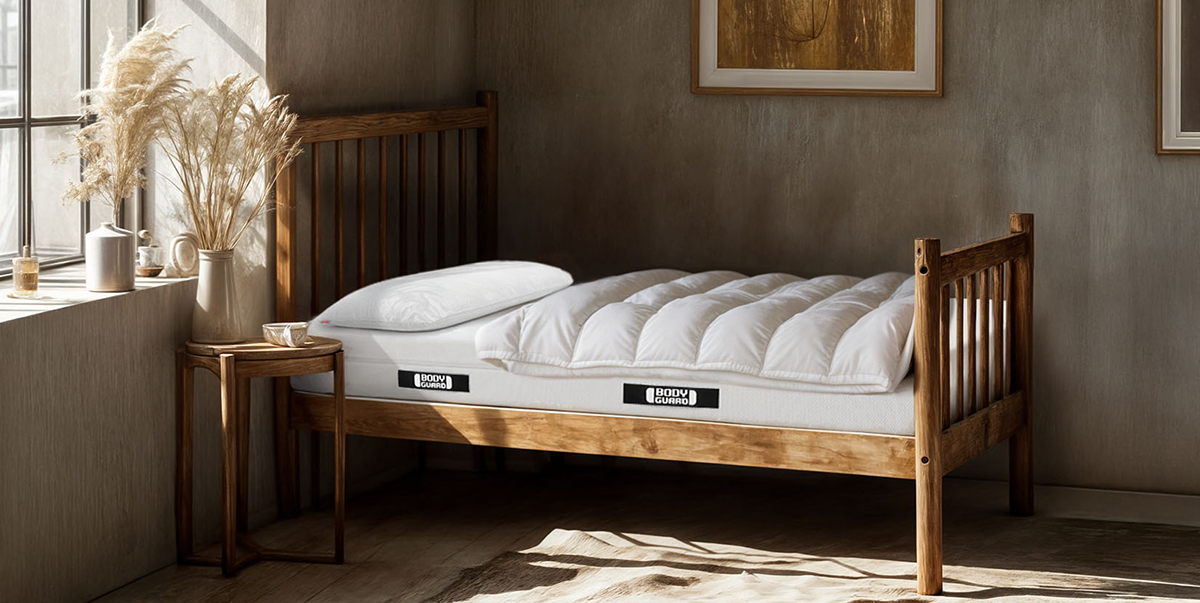 Photo: A BODYGUARD mattress 90x190 cm in an antique wooden bed in a historically furnished bedroom.