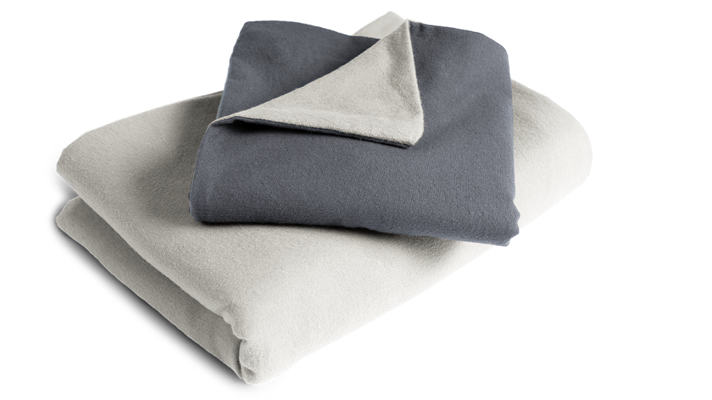 The folded flannel bed linen: the duvet cover is folded with the silver side facing outwards, the pillowcase with the anthracite-coloured side