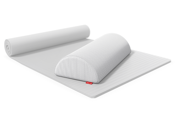 The knee and neck roll lies on a thin mat that is half rolled up.	