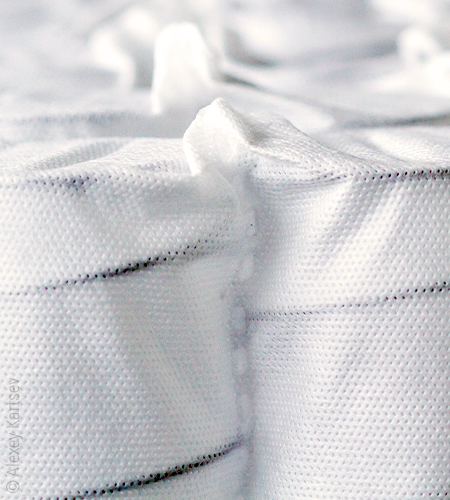  Dark metal feathers stand out under a slightly transparent fabric.