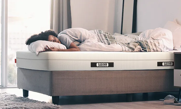 A person sleeps on the BODYGUARD Anti-Kartell-Matratze