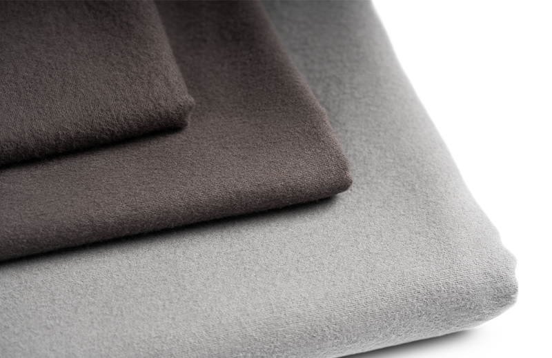 The folded BODYGUARD® Flannel Bed Linen: the duvet cover is folded with the silver side facing outwards, the pillowcase with the anthracite-coloured side