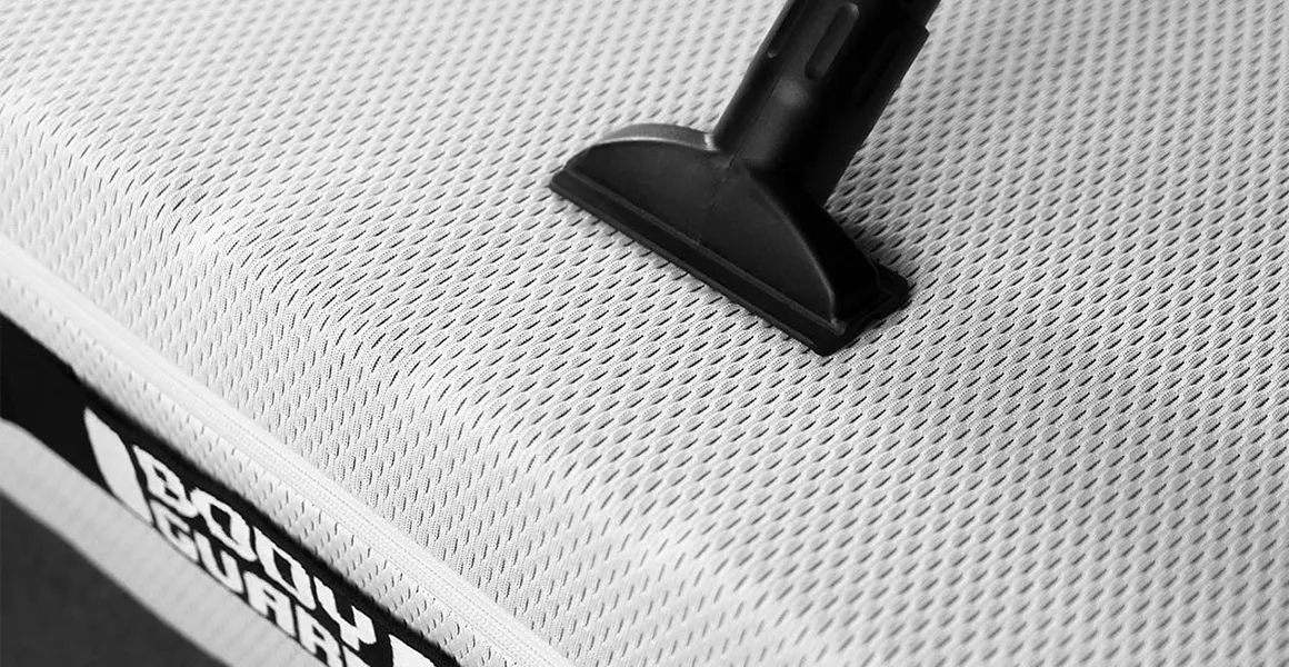 Photo: A vacuum cleaner nozzle on a mattress.