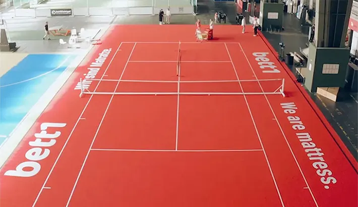 Foto aus der Vogelperspektive: Ein rotes Tennisfeld in einem alten Flugzeughangar