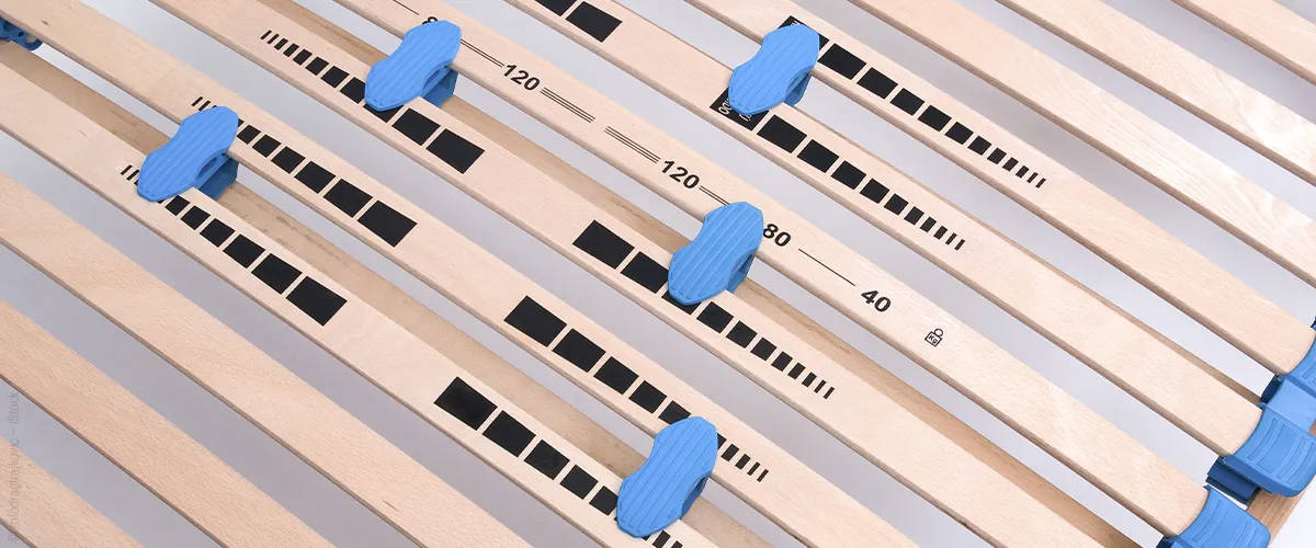 Close-up of a slatted frame with adjustable sliders in different positions