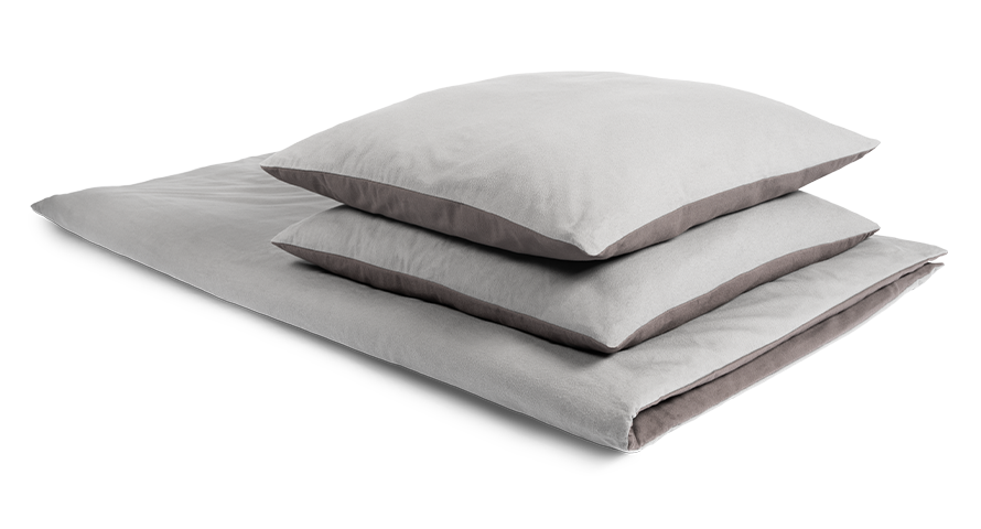 The BODYGUARD® Flannel Bed Linen covered on a folded duvet with two pillows. The Oeko-Tex® seal. Illustration of a hand closing a zip. Text: easy to cover	