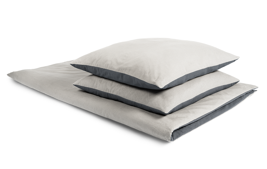 The BODYGUARD® Flannel Bed Linen covered on a folded duvet with two pillows. The Oeko-Tex® seal. Illustration of a hand closing a zip. Text: easy to cover	