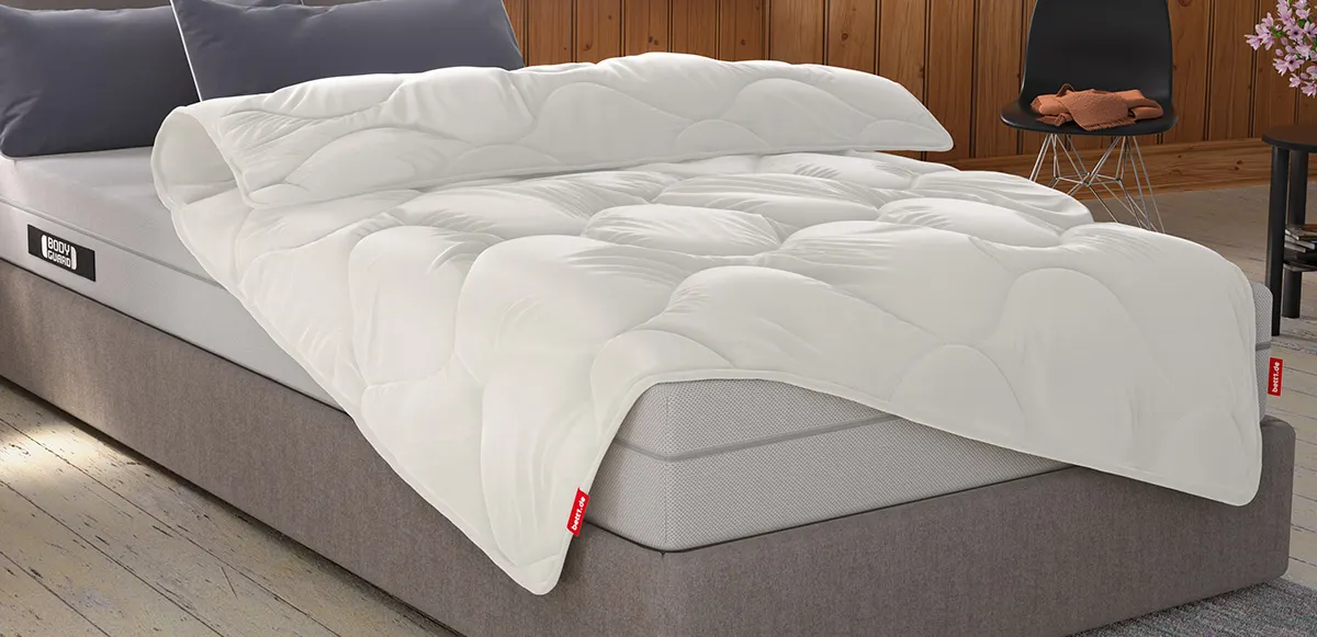 Bright bedroom with wood-panelled walls: A BODYGUARD Duvet 155x220 cm lies on a narrow single bed.
