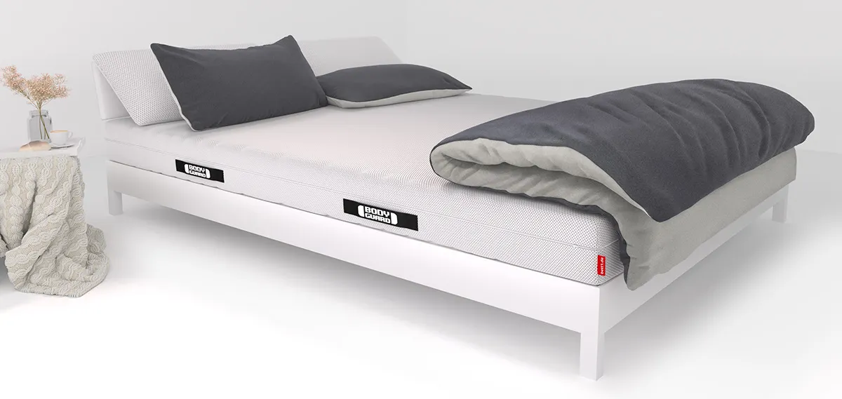 There are two pillows and a large comforter on a bed