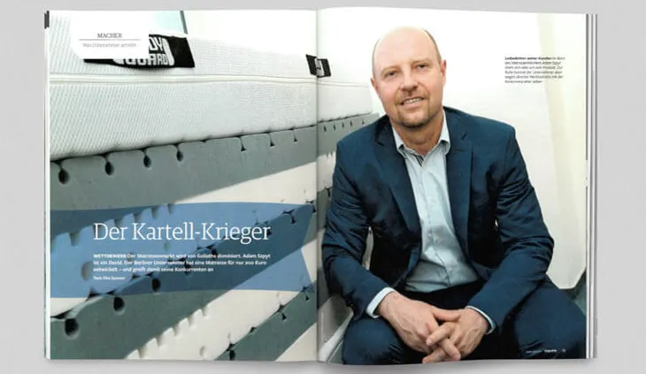 Aufgeschlagene Zeitschrift. Auf einer Doppelseite ein Foto von bett1-Gründer Adam Szpyt. Daneben eine BODYGUARD Matratze. Text: Der Kartell-Krieger