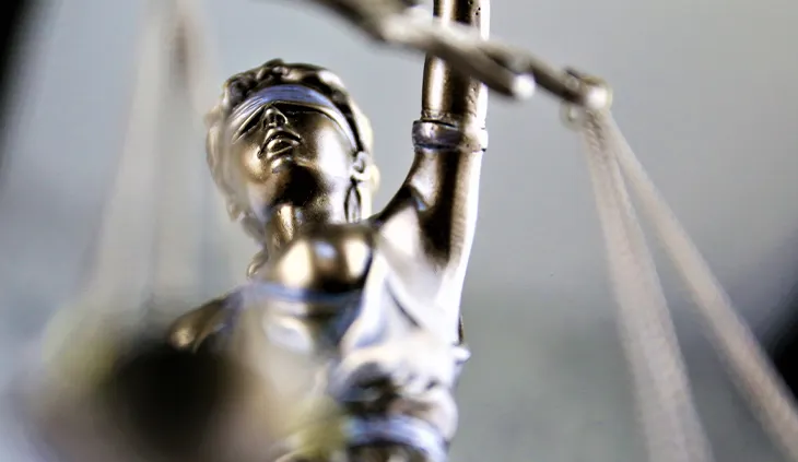 Ausschnitt einer glänzenden Statue der römischen Göttin Justitia.