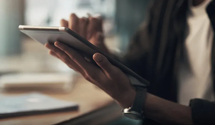 Eine Person mit Tablet in der Hand.