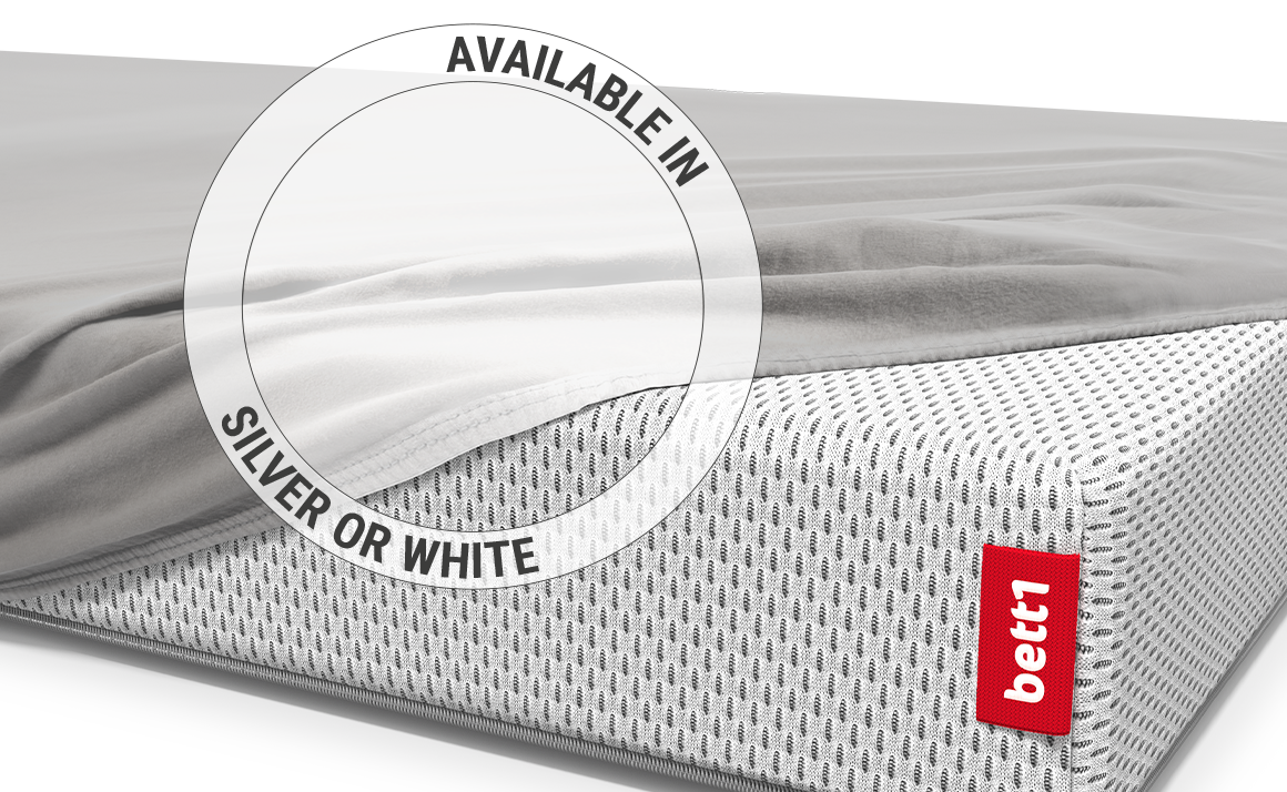  All but one corner of the BODYGUARD® children's mattress is covered with the children's fitted sheet in silver. Zoom on the sheet in the white colour version.  Text: Available in silver or white	