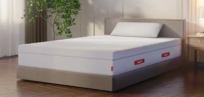 Die BODYGUARD Boxspring Matratze Weich auf einem Bett in einem hellen Schlafzimmer.