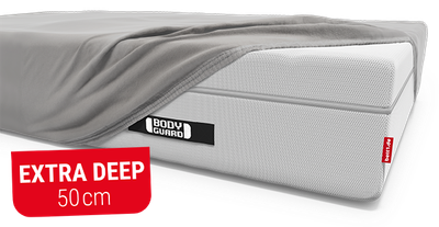 The BODYGUARD mattress, half-covered with the BODYGUARD jersey fitted sheet. Text: Extra deep 50 cm