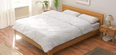 Foto: In einem Schlafzimmer steht ein Doppelbett. Darauf liegen zwei BODYGUARD Kissen und eine BODYGUARD Paar-Bettdecke.