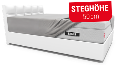 Weißes Bett mit BODYGUARD Boxspring Matratze und BODYGUARD Spannbettlaken extra hoch. Textbox: Steghöhe 50 cm.