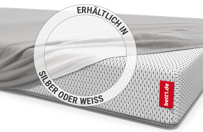 Die BODYGUARD® Kindermatratze ist bis auf eine Ecke mit dem Kinder-Spannbettlaken in Silber bezogen. Zoom auf das Laken in der weißen Farbvariante.  Text: Erhältlich in Silber oder Weiß
