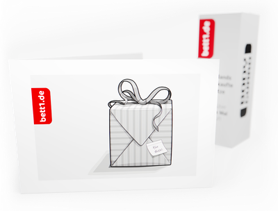 Der bett1.de Geschenkgutschein mit Geschenkpaket-Motiv steht leicht aufgeklappt vor einem Matratzenkarton.