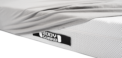 Half of the BODYGUARD mattress is covered with the BODYGUARD fitted sheet