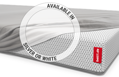  All but one corner of the BODYGUARD® children's mattress is covered with the children's fitted sheet in silver. Zoom on the sheet in the white colour version.  Text: Available in silver or white