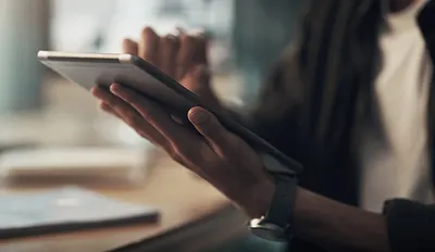 Eine Person mit Tablet in der Hand.